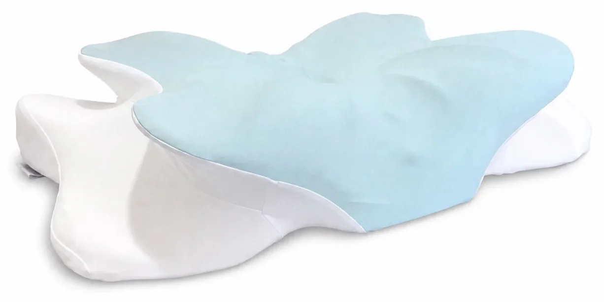 The pillow off the bed against a white background, seen from above and in front, with a deep half-moon scoop carved out of the foam on the near side and a second one at the far end.