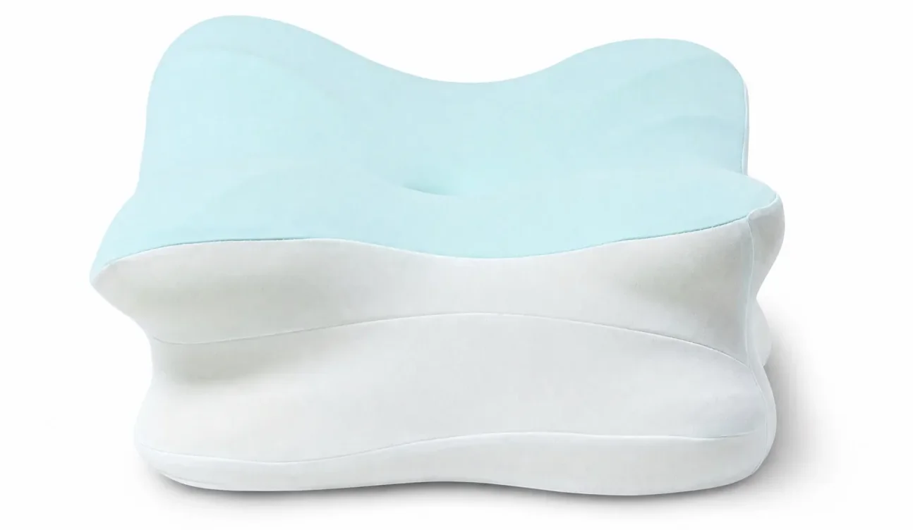 The pillow end-on against a white background: the pale blue top surface dips to a hollow in the middle and rises again at both ends, over a white foam base in two stepped layers.